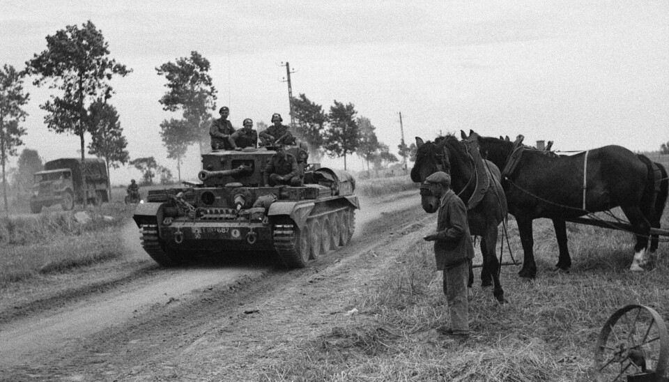 En tank passerer en mann og hester i Normandie, 1944